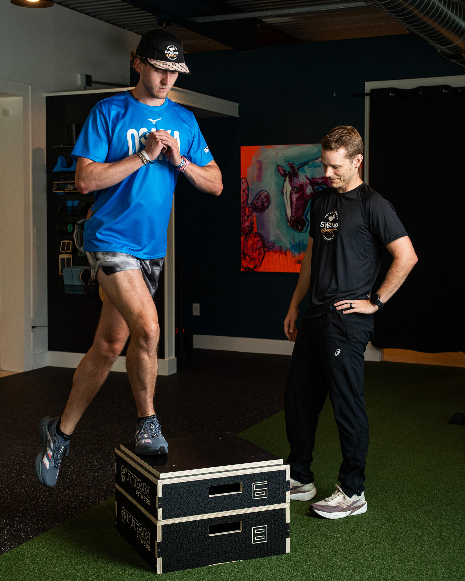 Runner performing a heavy trap-bar deadlift while a Doctor of Physical Therapy at Swamp Rabbit Physiotherapy coaches from behind