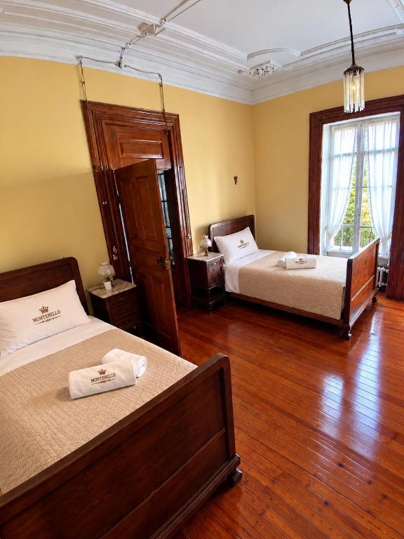 Quarto amarelo com duas camas individuais em madeira escura