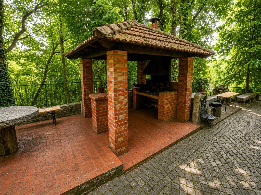Churrasqueira em tijolo com telheiro no jardim