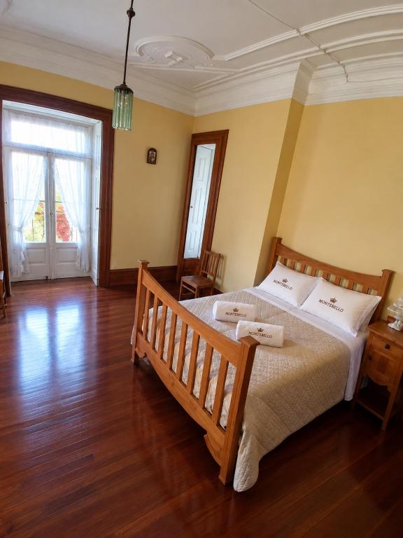 Quarto amarelo com cama de casal em pinho e varanda