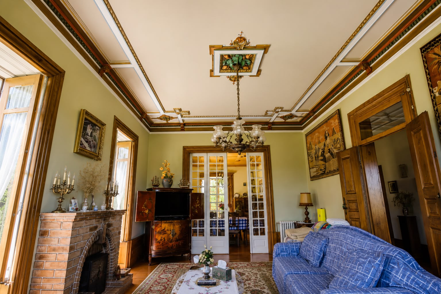 Sala de estar com teto trabalhado, lareira e sofá