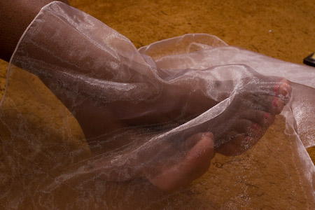 Feet veiled in sheer organza on a warm gold ground