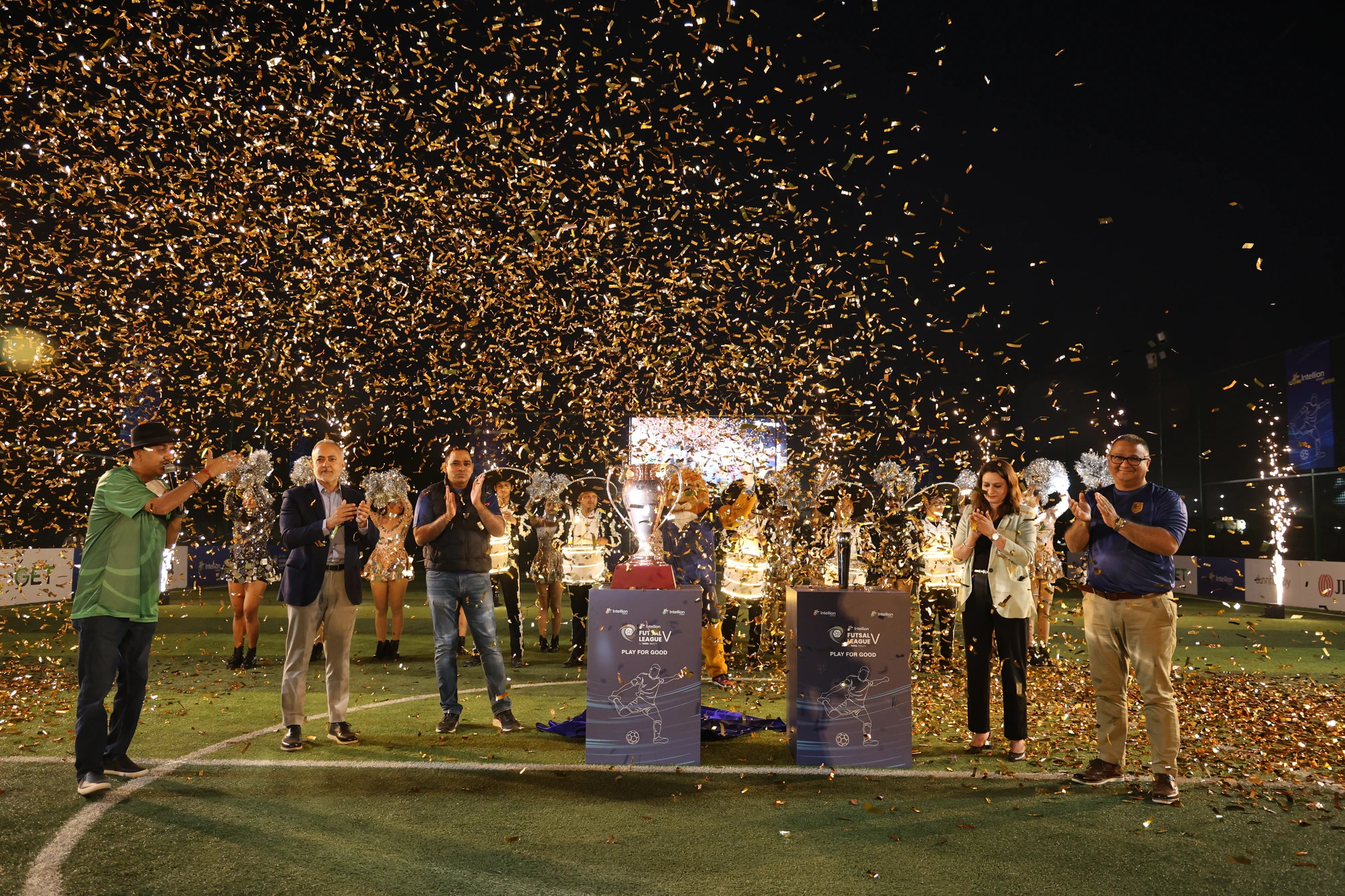 Trophy reveal moment on a lit football pitch with golden confetti